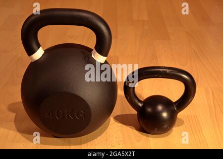 Heavy and light kettlebell on wooden background Stock Photo