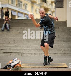 Male street dancer performing tap dance on the pavement. June 2, 2012. Kiev, Ukraine Stock Photo