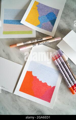 Colored pencils and papers on white background Stock Photo