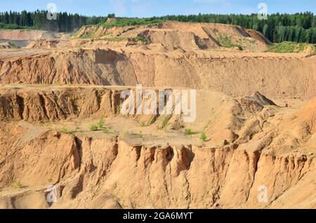 Background of mountain showing yellow soil and rock. View on the canyon with cracks in sand. Mining and Water Pollution. Exhausted quarry after excava Stock Photo