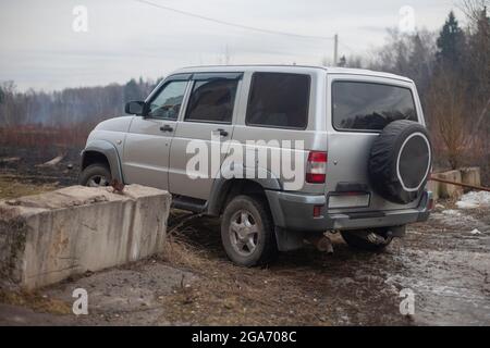 The SUV is driving through a roadblock. The car is driving on a bad road. A lot of personal transport. Stock Photo