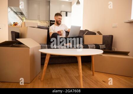 Young man using laptop computer and drinking tea Stock Photo