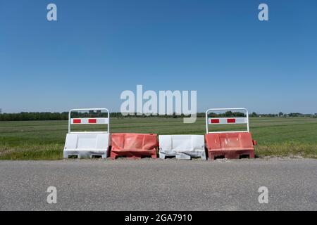 Orange barrels, barricades, and signs blocking a road in the Netherlands Stock Photo