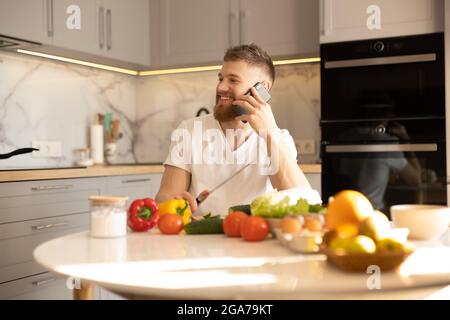 Man talking on mobile phone while sitting at table Stock Photo