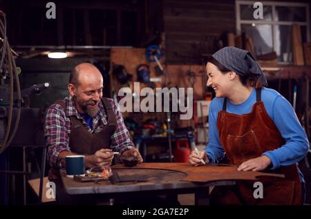 Male And Female Blacksmith Working On Design In Forge Together Stock Photo
