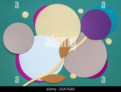 Circles of different sizes and colours on dark green background. Paper collage. Copy space. Flat lay, top view. Stock Photo