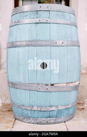 Large blue wooden barrel stands on a tile against the wall Stock Photo