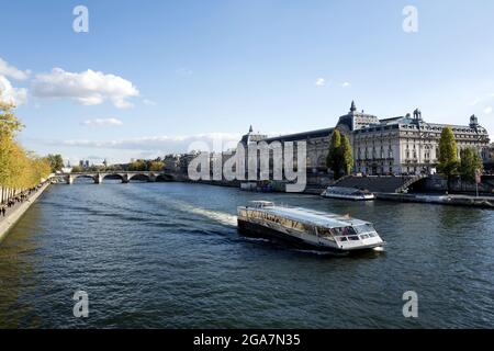 Bateaux Mouche, tourist boat tour on Seine river, with the Orsay Museum building in the background, in Paris Stock Photo