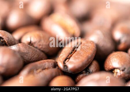 A macro photo of fried brown coffee beans on the table. Freshly roasted coffee beans background Stock Photo