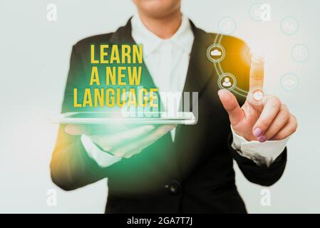 Conceptual display Learn A New Language. Business idea ability to communicate in the second orforeign language Woman In Suit Holding Tablet Pointing Stock Photo