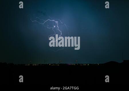 Capriciously shaped lightning bolt high up in the sky Stock Photo