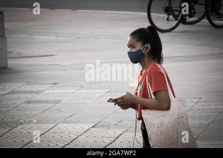 Teenager girl with mask in a street during pandemic times. Stock Photo