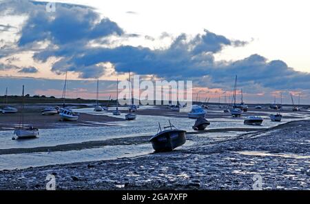 A view of small craft beached at low water prior to sunrise on the North Norfolk coast at Brancaster Staithe, Norfolk, England, United Kingdom. Stock Photo