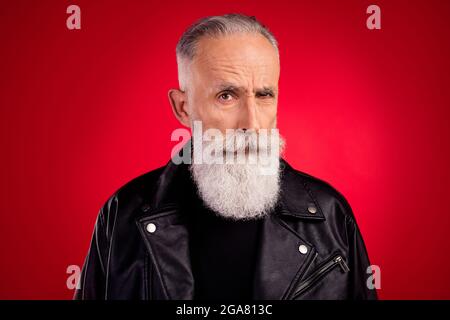 Portrait of attractive minded skeptic serious cool grey-haired man looking suspiciously isolated over bright red color background Stock Photo