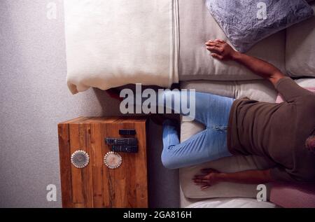 Overhead Close Up Of View Of Man Relaxing On Sofa At Home Watching TV Stock Photo