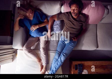 Overhead View Of Mature Couple With Pregnant Woman Relaxing On Sofa At Home Together Stock Photo
