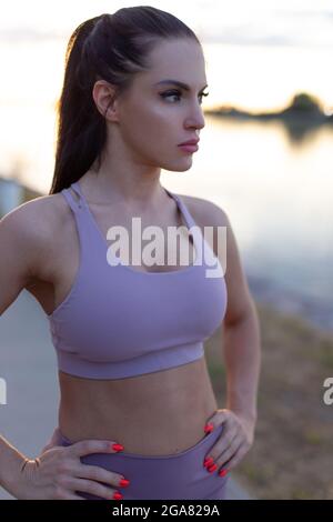 Young woman in sportswear resting at river, inner balance Stock Photo