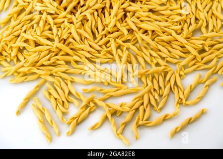 Italian traditional homemade pasta. Strozzapreti macaroni on white background. Top view Stock Photo