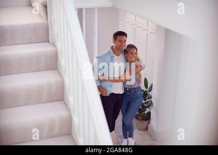 Excited Couple Standing And Hugging In Hallway Of New Home On Moving Day Stock Photo