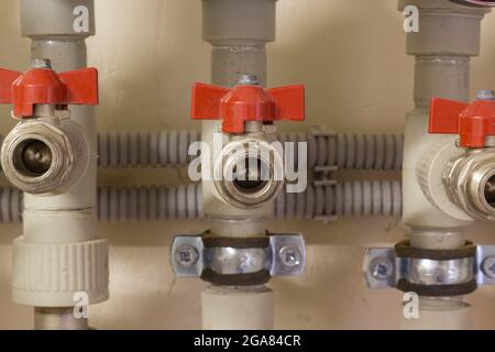 Distribution of plastic pipes with red valve and clamps Stock Photo