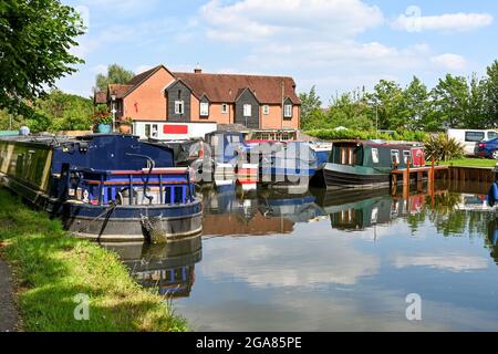 Newbury, Berkshire, England - June 2021: Houseboats moored in a marina on the Kennet and Avon Canal in the centre of Newbury. Stock Photo