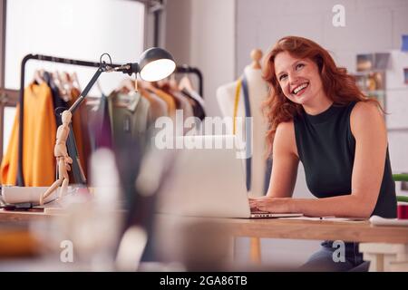 Female Student Or Business Owner Working In Fashion Using Laptop In Studio Stock Photo