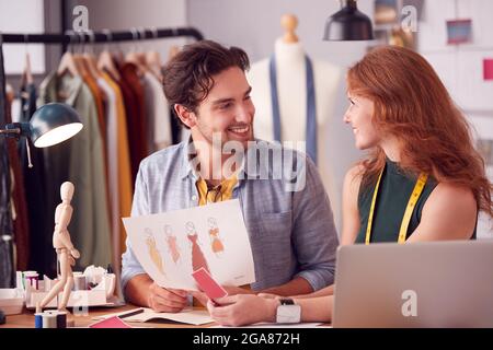 Male And Female Students Or Business Owners Working On Designs In Fashion Studio Together Stock Photo