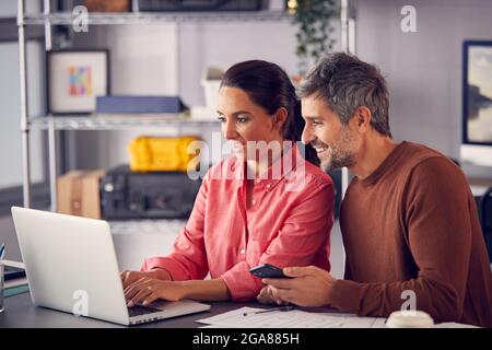 Male And Female Advertising Marketing Or Design Creatives Collaborating On Project In Studio Stock Photo