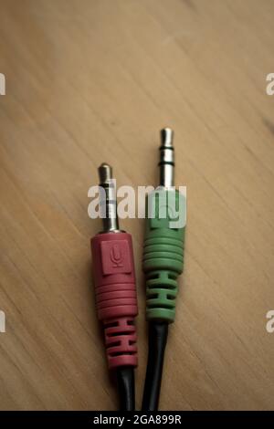 Colorful earphones cables connection on a wooden table Stock Photo
