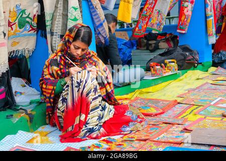 Kolkata, West Bengal, India - 31st December 2018 : Young Bengali female artist painting Pattachitra or Patachitra - traditional, cloth-based scroll pa Stock Photo