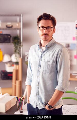 Portrait Of Serious Male Architect In Office Standing By Desk Stock Photo