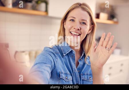 POV Shot Of Female Vlogger Holding Mobile Phone Camera Making Social Media Video At Home Stock Photo