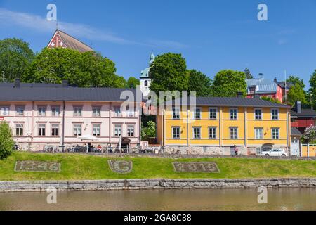 Porvoo, Finland - June 12, 2015: Colorful houses on the river coast in historical Finnish town, ordinary people walk the street Stock Photo