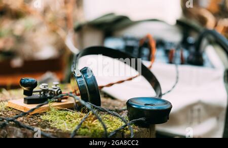 Russian Soviet Portable Radio Transceiver Used By USSR Red Army Signal Corps In World War Ii. Headphones And Telegraph Key Are On A Forest Stump Stock Photo