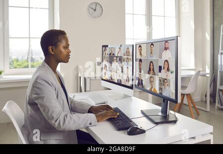 Business woman using multiple computers during virtual staff training and work meetings Stock Photo