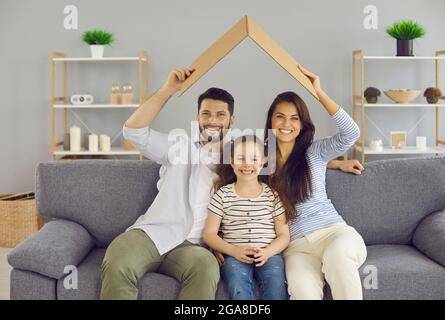 Portrait of happy young European family with daughter relax under roof celebrate relocation to own home. Stock Photo