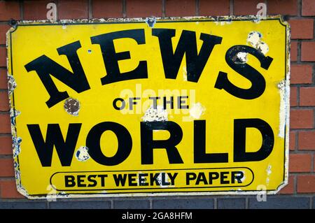 Old Fashioned Metal Sign Advertising The News Of The World Newspaper Which Was A Sunday Weekly Publication In The United Kingdom from 1843 to 2011 Stock Photo
