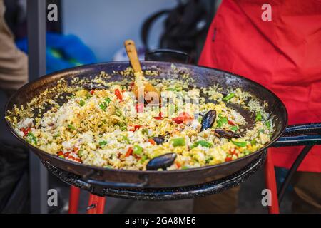 https://l450v.alamy.com/450v/2ga8me6/large-frying-pan-with-cooked-spanish-paella-with-seafood-summer-picnic-on-backyard-outdoors-food-barbecue-street-food-concept-2ga8me6.jpg