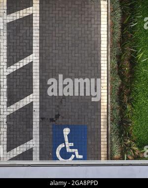 Disabled dedicated parking place marked with blue wheel chair symbol. Stock Photo