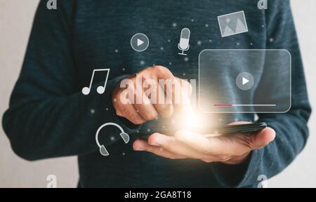 Close up hands holding smartphone. man using cellphone for streaming online watching video on internet live concert show or tutorial.technology busine Stock Photo
