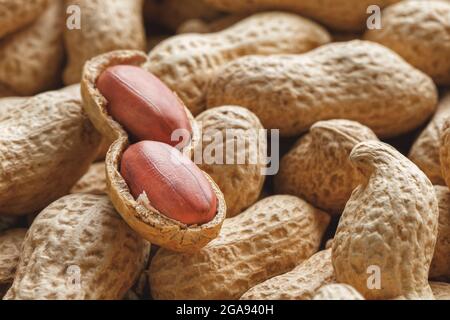 Peeled peanut on well peanuts. Uncleaned inshell peanuts. Peanuts, for background or textures. Stock Photo