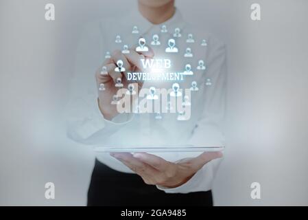 Conceptual display Web Development. Word for work involved in developing a website for the Internet Lady In Uniform Standing Holding Tablet Typing Stock Photo