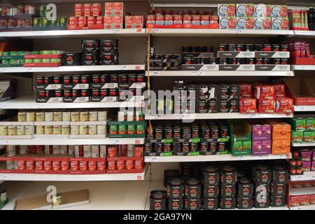 Taplow, Buckinghamshire, UK. 22 July, 2021. Tinned tomatoe supplies. Shelves in Sainsbury's Supermarket were generally very well stocked this morning. The main exception was for mineral water as people have been buying more than normal due to the heatwave. Following the Covid-19 lockdown lifting on Monday, Sainsbury's have new signs outside their store asking customers to wear masks if they can. Credit: Maureen McLean/Alamy Stock Photo