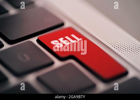 Close up shot of Enter button laptop computers enter button with Sell text written on red. Stock Photo