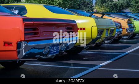 PLYMOUTH, MI/USA - JULY 26, 2021: Four vintage Detroit muscle cars, including a Plymouth Roadrunner, at Concours d'Elegance of America car show. Stock Photo