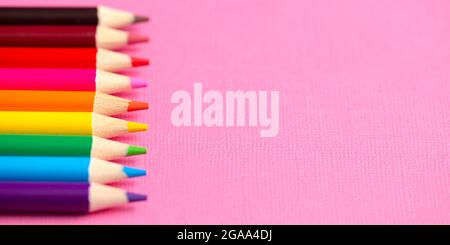 Set of Rainbow Colored Pencils on a Bright Pink Background Stock Photo