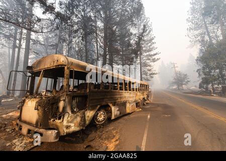 A burned out bus sits by the side of the road on Nov 10th, 2018 in Paradise California after being abandoned by residents fleeing the deadly Camp Fire Stock Photo