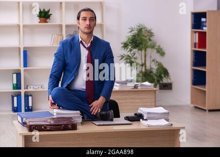 Young businessman employee doing yoga exercises during break Stock Photo