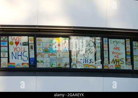 Children's drawings line windows close to St Thomas' Hospital in London as people give thanks to the NHS during the Covid-19 pandemic. Stock Photo