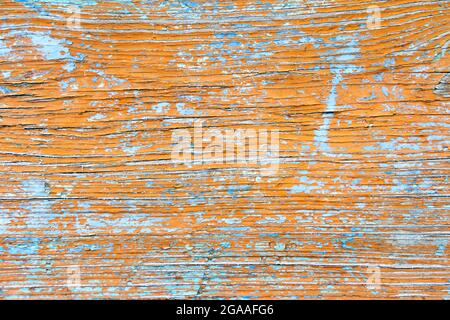 Texture of old boards with cracked orange and blue two layer paint. Grunge vintage aged background.  Stock Photo